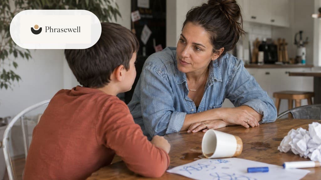 Parent sitting calmly with a child at the kitchen table after a spill, listening without escalating
